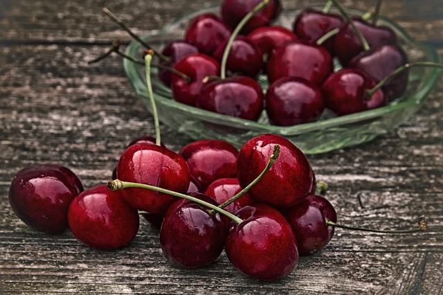 group of fresh cherries on wood table
