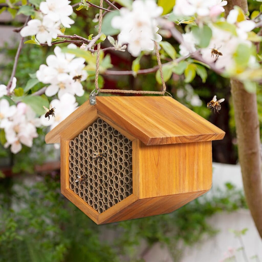 a wooden bee house hanging in the garden with small honeybees nearby